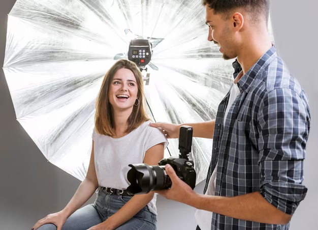 A guy takes pictures of a girl in a photo studio